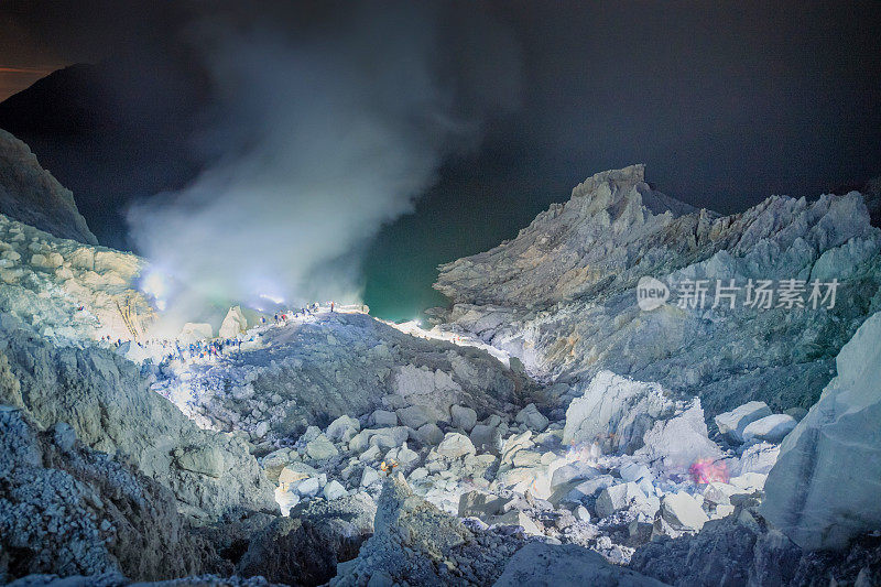 Sulfur lake and smoking mine mountain in the morning at Kawah Ijen volcano East Java Indonesia with milky way night sky background